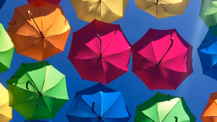 Bunte Regenschirme vor blauem Himmel